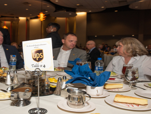 UPS table sign and people sitting at table